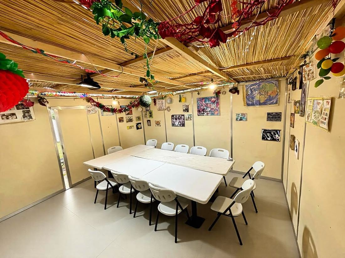 A decorated sukkah interior with lights, tables and chairs set up